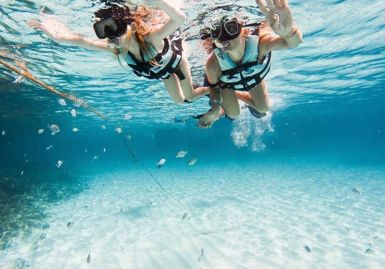 niños haciendo snorkel en Cancún